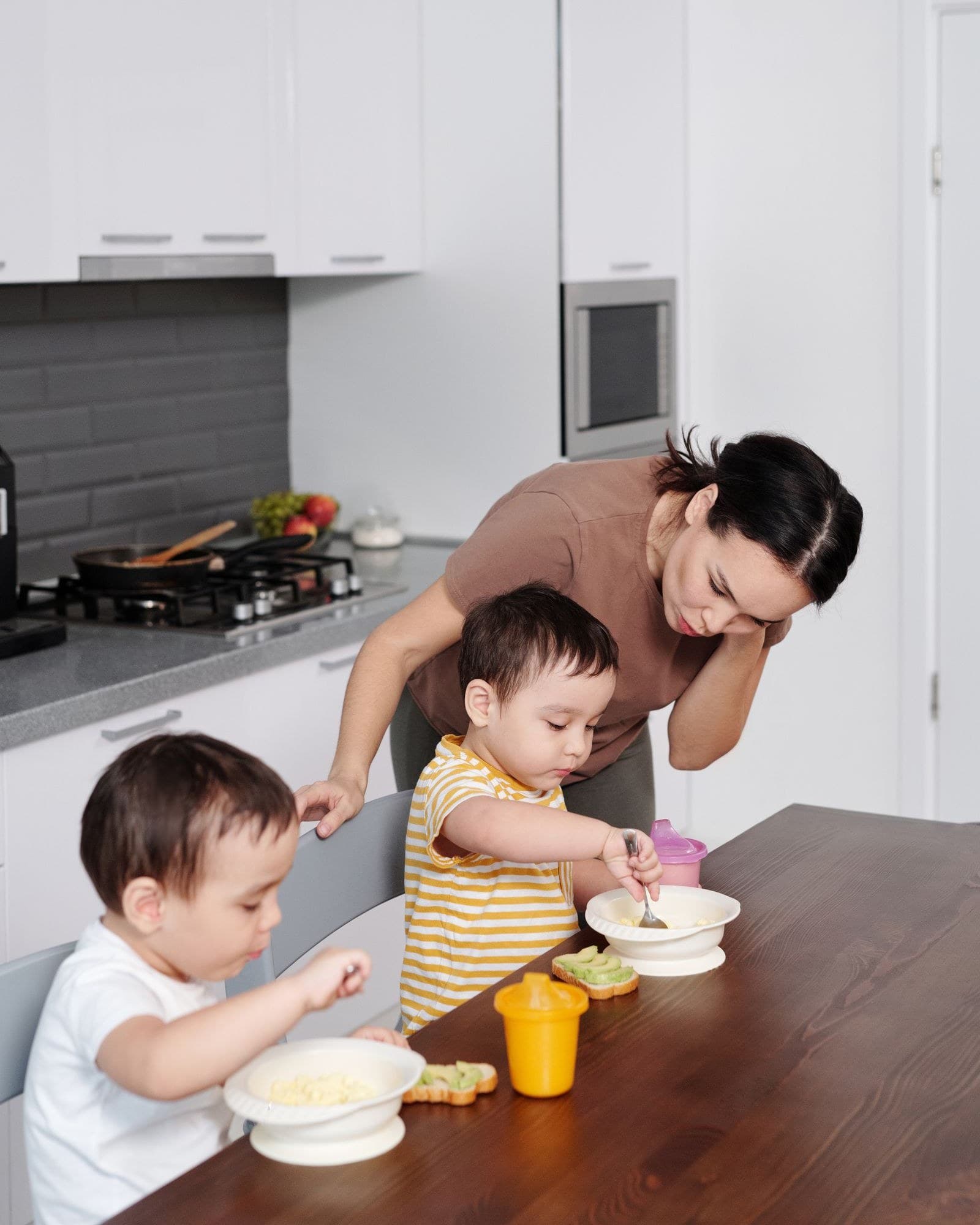 A helper clearing up a family kitchen after school